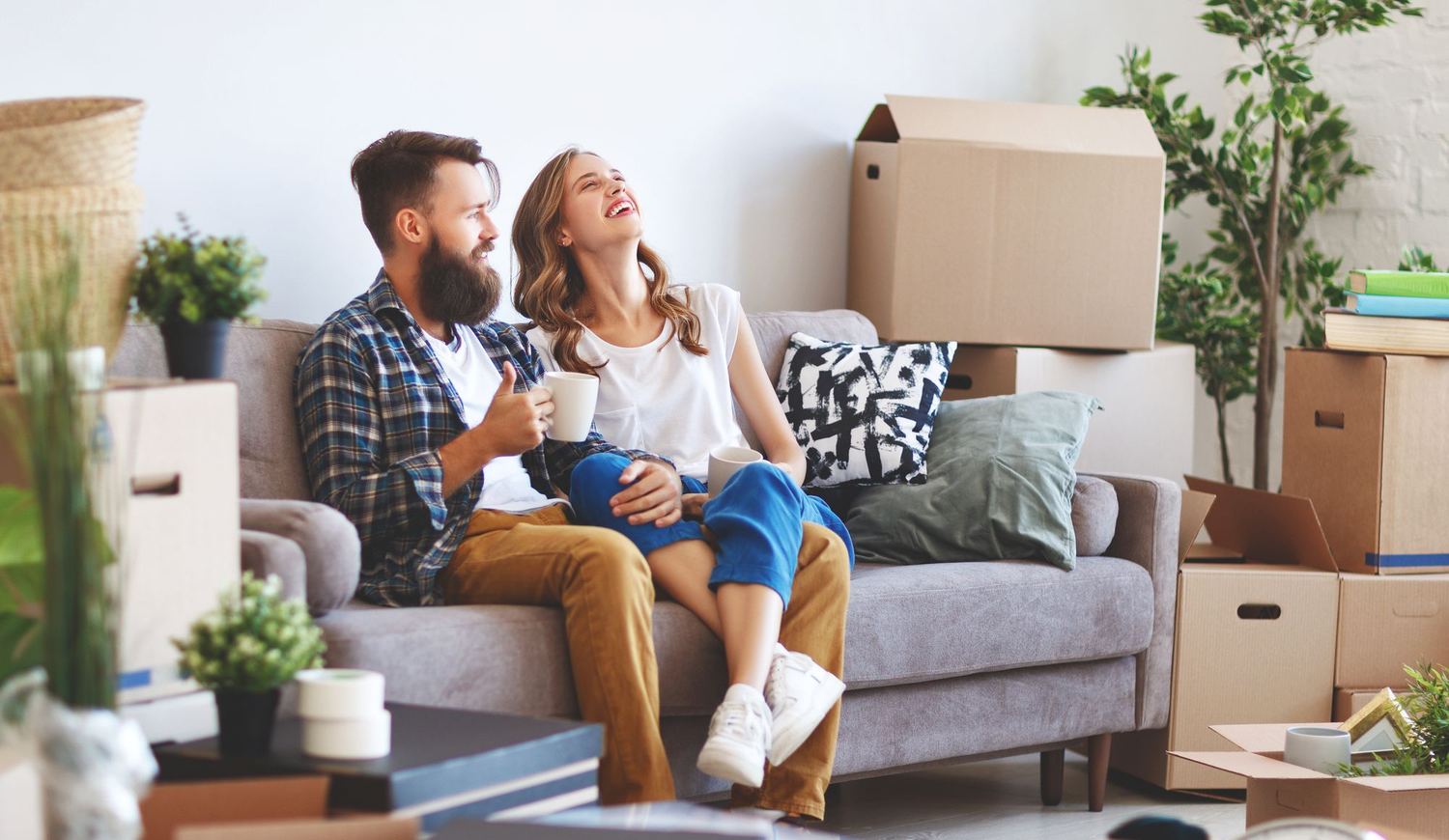A young couple sitting among moving boxes in a new home.