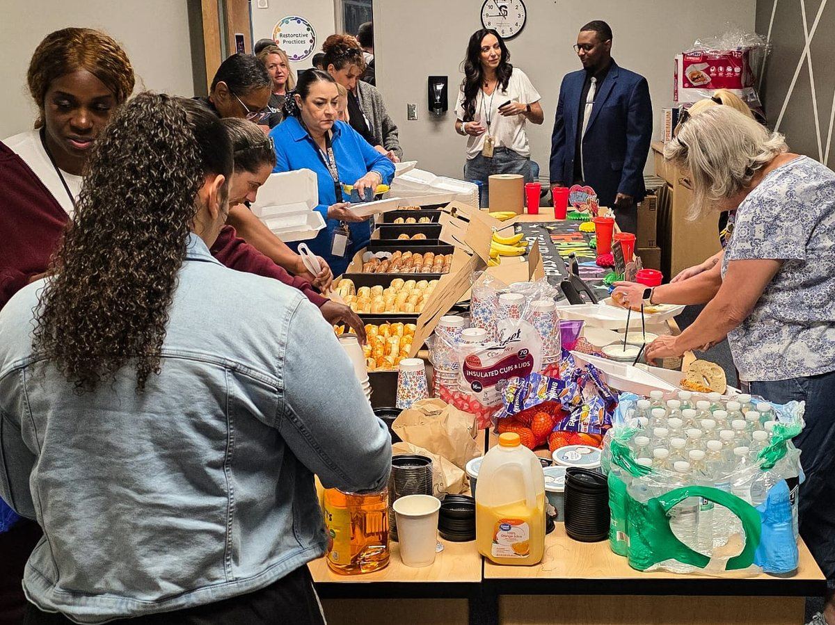 Teachers gathering at a Teacher Appreciation Week breakfast in a school staff room