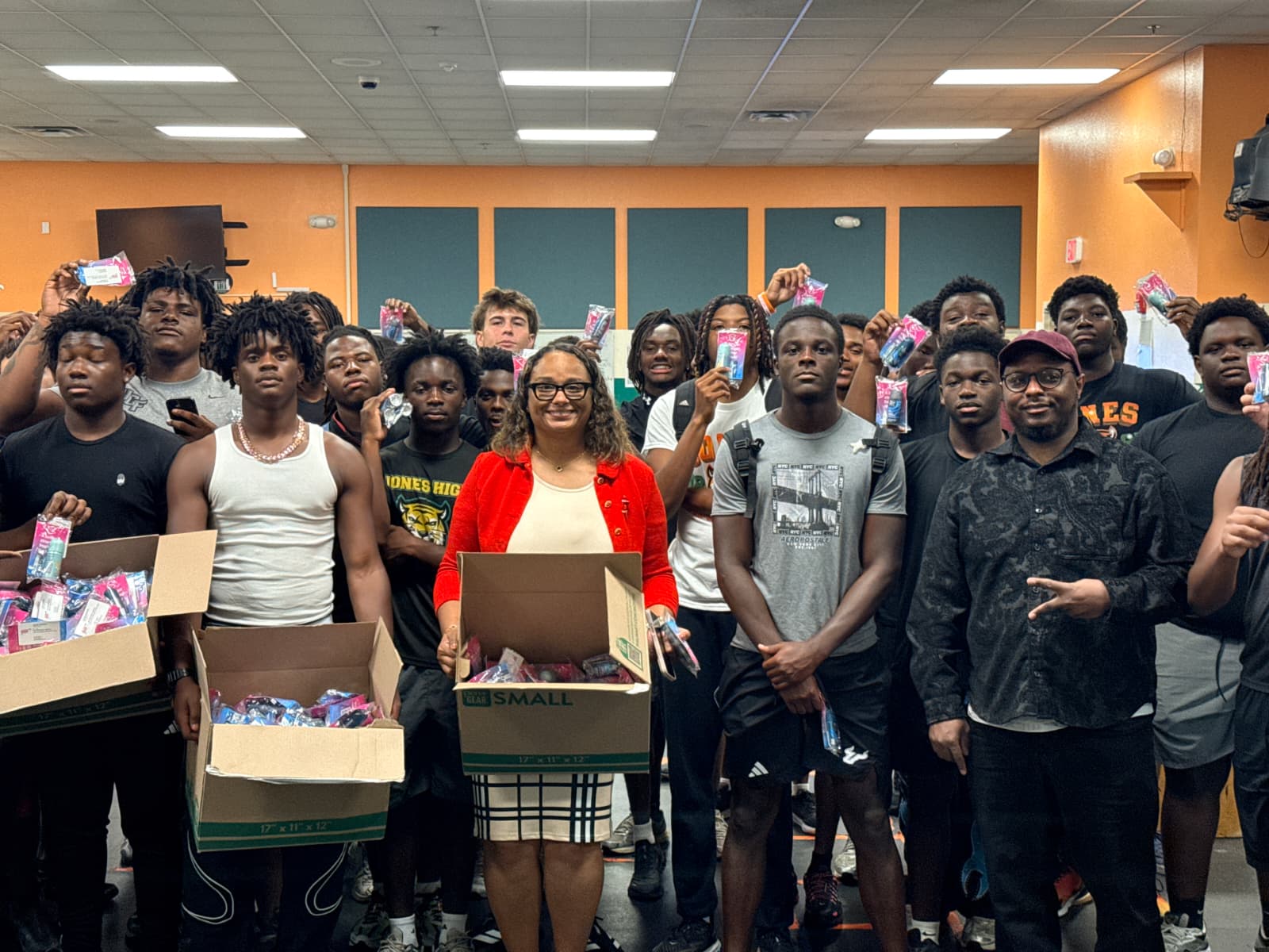 Derrick Johnson with Jones High School students and staff holding boxes of donated school supplies