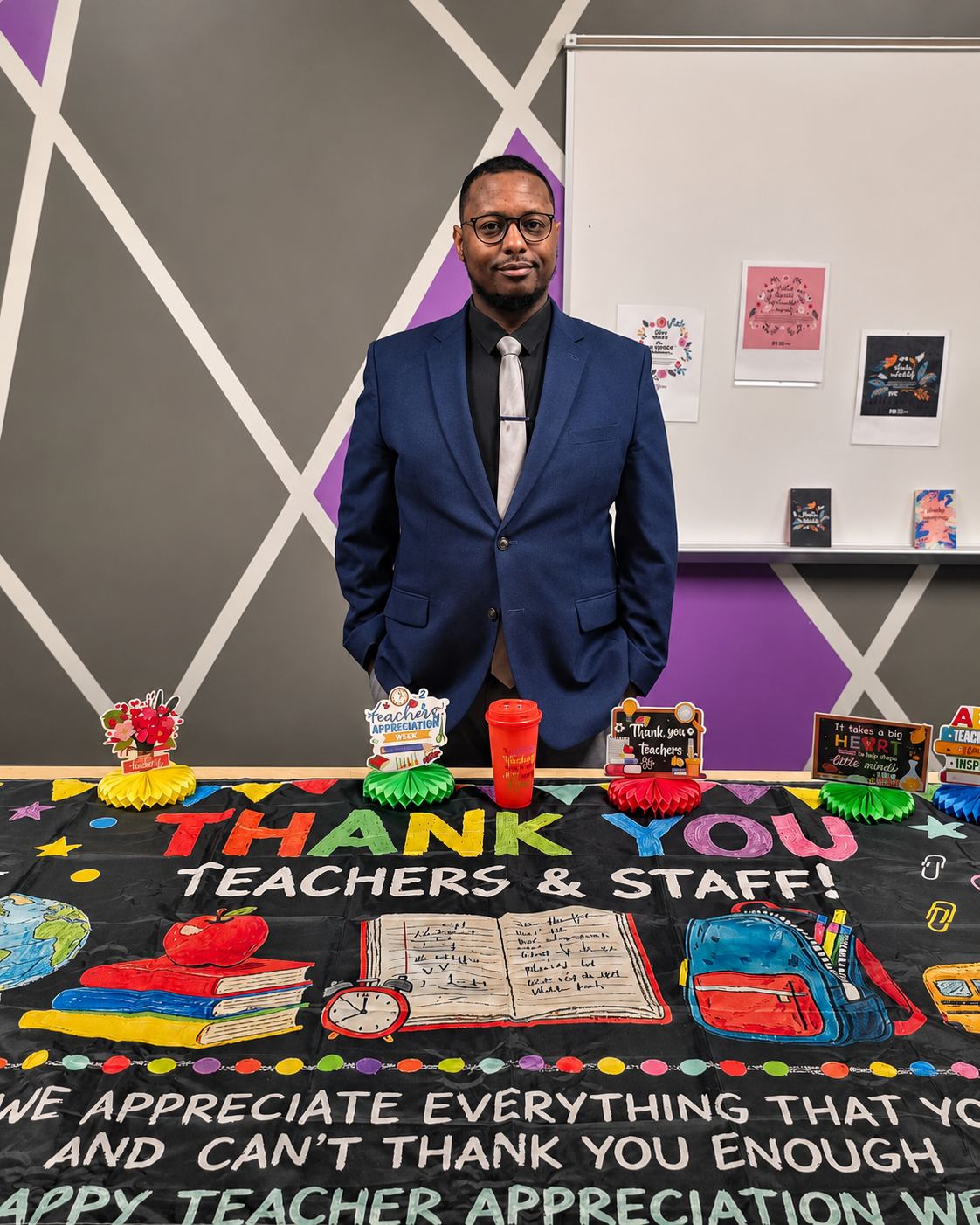 Derrick Johnson standing behind a Thank You Teachers & Staff table during Teacher Appreciation Week