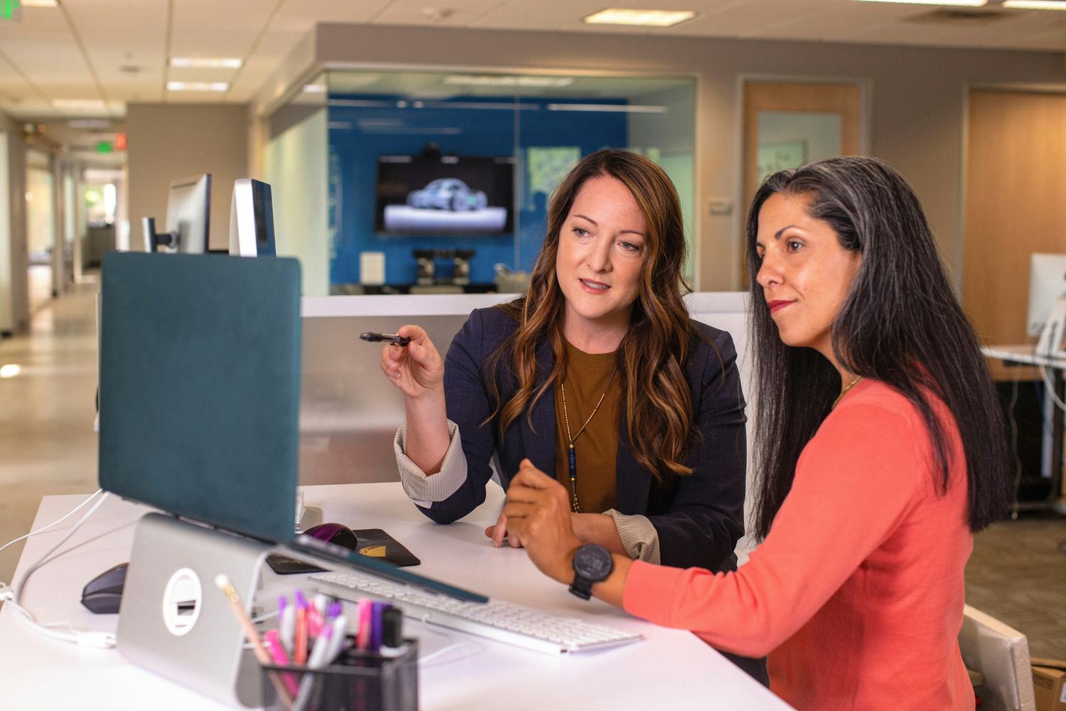 Two people working through documents at a desk
